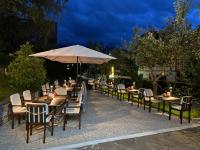 eine Reihe von Tischen und Stühlen mit einem Sonnenschirm in der Unterkunft Hotel-Restaurant Batzenhäusl in Innsbruck