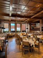 ヴェステンドルフにあるHotel Mesnerwirtのテーブルと椅子と窓のあるダイニングルーム