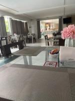 uma sala de jantar com uma mesa de vidro com um vaso de flores cor-de-rosa em Hotel Master em Jequié