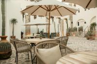 un patio con mesas y sillas con sombrillas en Altamonte Hotel Boutique, en Bernal
