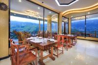 a dining room with tables and chairs and windows at Longji Thousand - layer Terraces View Hotel in Longsheng