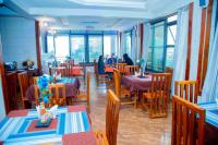 KasuluBWAMI DUBAI HOTEL KASULU的一间设有桌椅的餐厅,那里有座位