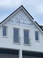 a white building with a sign on top of it at Hotel am Pferdemarkt in Aurich