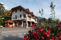 een groot gebouw met rode bloemen ervoor bij Le Comptoir de Sebastien - La Plage et Le Port - 2 duplex - 100m de la plage de Talloires in Talloires
