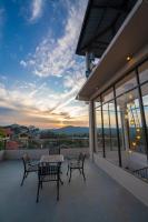 two benches and a table on a balcony with a sunset at IRIS Kandy in Kandy