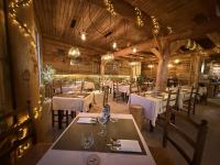 Un comedor con mesas, sillas y luces. en Hotel des Pyrénées, en Font-Romeu