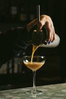 una persona que vierte una bebida en un vaso en Gandum Village - Conscious Boutique Hotel, en Montemor-o-Novo