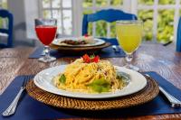 un piatto di spaghetti su un tavolo con due bevande di Hotel Fazenda Santanna ad Amparo