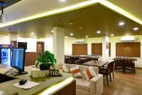 a restaurant with a waiting room with tables and chairs at Hotel Alaina in Karukachal