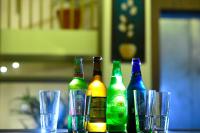 four bottles of beer sitting on a table with glasses at Hotel Alaina in Karukachal
