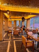 a restaurant with tables and chairs and windows at Apurwa Grand Resort in Baragrān