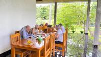 a group of people sitting around a wooden table at Tangkoko Hideaway Cottage in Pulau Mogogimbun