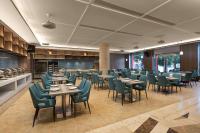 um restaurante com mesas e cadeiras em uma sala em Ramada by Wyndham Zhangjiajie Tianmen Mountain em Zhangjiajie