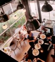 een groep mensen die aan een tafel zitten met eten bij Human Touch Room - Soulful Bangkok Hideout in Lat Krabang