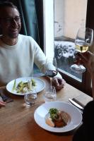 a man sitting at a table with two glasses of wine at Au Vieux Moulin in Megève