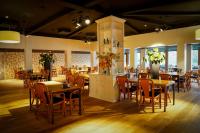 um restaurante com mesas e cadeiras em uma sala em Resort Bad Boekelo - Hotel met Spa & Wellness in Enschede em Enschede