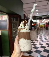 een persoon die een chocolademilkshake met een rietje vasthoudt bij Villa 26, Estuary Country Estate, Port Edward, KZN in Port Edward