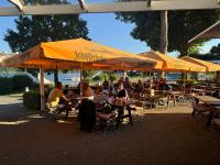 Un groupe de personnes assises à des tables sous des parasols dans l'établissement Edersee-Apartment, à Waldeck