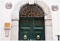 una puerta verde en un edificio con un arco en Domus Julia, en Roma
