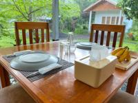 a wooden table with plates and bananas on it at Tangkoko Hideaway Cottage in Pulau Mogogimbun