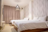 a bedroom with two beds and a large window at Haogong Hotel in Taichung