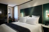 a bedroom with a large white bed with a green wall at Academias Hotel, Autograph Collection in Athens