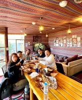 瓦迪穆萨RoadHouse - Petra的一群人坐在餐厅的一张桌子旁