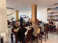 un grupo de personas sentadas en mesas en un restaurante en Vang Vieng Green hotel 1, en Vang Vieng