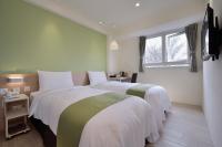a bedroom with two beds and a window at Green Hotel - Fengjia in Taichung