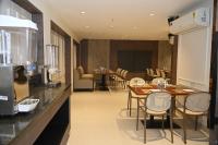 een eetkamer met tafels en stoelen en een keuken bij Hotel Bagla Atithi Banaras in Varanasi