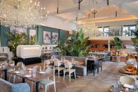 a restaurant with tables and chairs and chandeliers at The College Hotel Amsterdam, Autograph Collection in Amsterdam