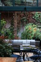 マドリードにあるVP Jardín de Recoletosのテーブルと椅子、テーブルとベンチのあるパティオに座っている