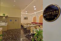 um restaurante com mesas e cadeiras e um relógio na parede em Hotel Grand Continent Gachibowli - US Consulate em Gachibowli