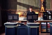 Ein Mann steht hinter einem Tresen mit zwei Computermonitoren. in der Unterkunft The Elephant Hostel in Amsterdam