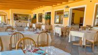 a restaurant with tables and chairs with white tablecloths at Solone Beach Resort in Marina di Ascea
