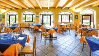 a restaurant with blue tables and chairs and windows at Solone Beach Resort in Marina di Ascea