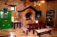 a kitchen with a brick oven with a table and chairs at Guest House Stara Baranja in Kneževi Vinogradi