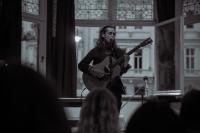 a man playing a guitar in a room at Astor Hyde Park Hostel in London