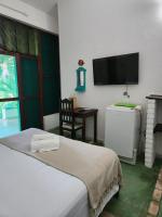 a bedroom with a bed and a flat screen tv at Pousada São Francisco in Cumuruxatiba
