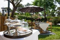 a table with a plate of food and an umbrella at Ferret Vigne - Villa Chambres d&#39;Hôtes in Cap-Ferret