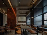 a restaurant with tables and chairs and windows at 欢桔酒店 郑州二七广场丹尼斯大卫城店 in Zhengzhou