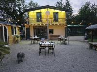 einem Hund, der vor einem Haus mit Tischen und Stühlen läuft in der Unterkunft Tente Lodge Safari in Saint-Martin-des-Besaces