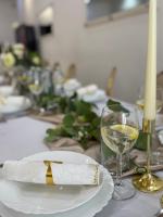 ein Tisch mit einem weißen Teller und einem Glas Wein in der Unterkunft Nostalgia restaurant & pension in Rimavská Sobota