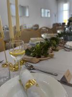 einen Tisch mit einer weißen Platte und Gläsern Wein in der Unterkunft Nostalgia restaurant & pension in Rimavská Sobota