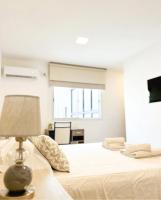 Dormitorio blanco con cama y lámpara en HOTEL PUCARA La Rioja, en La Rioja