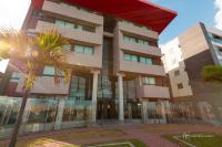un edificio con una palmera delante en Rede Andrade Boa Viagem, en Recife