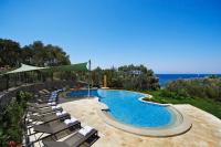 a swimming pool with chairs and the ocean in the background at Mandarin Oriental, Bodrum in Golturkbuku