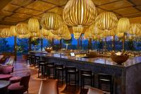 a restaurant with a bar with chairs and chandeliers at Mandarin Oriental, Bodrum in Golturkbuku