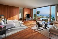 a bedroom with a large bed and a living room at Mandarin Oriental, Bodrum in Golturkbuku