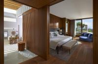 a bedroom with a large bed and a blue couch at Mandarin Oriental, Bodrum in Golturkbuku